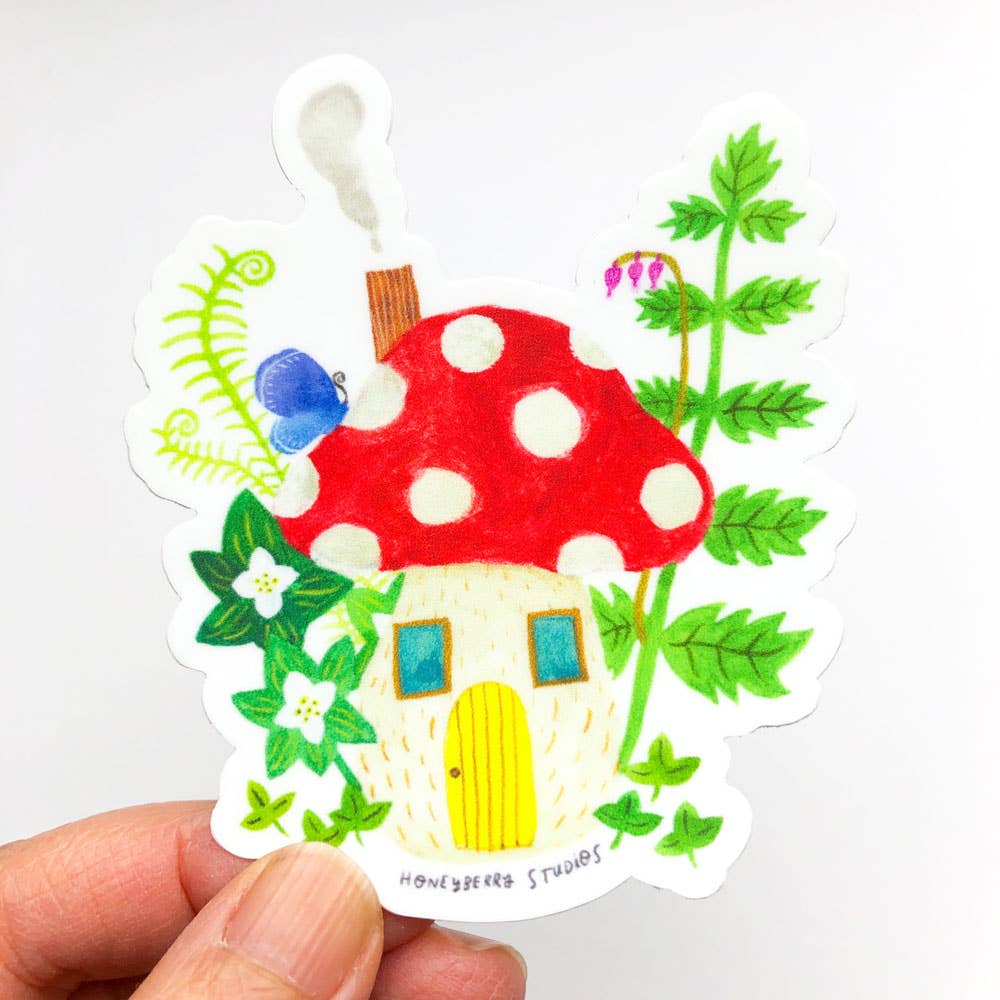 Colorful mushroom-shaped house sticker with greenery on a white background