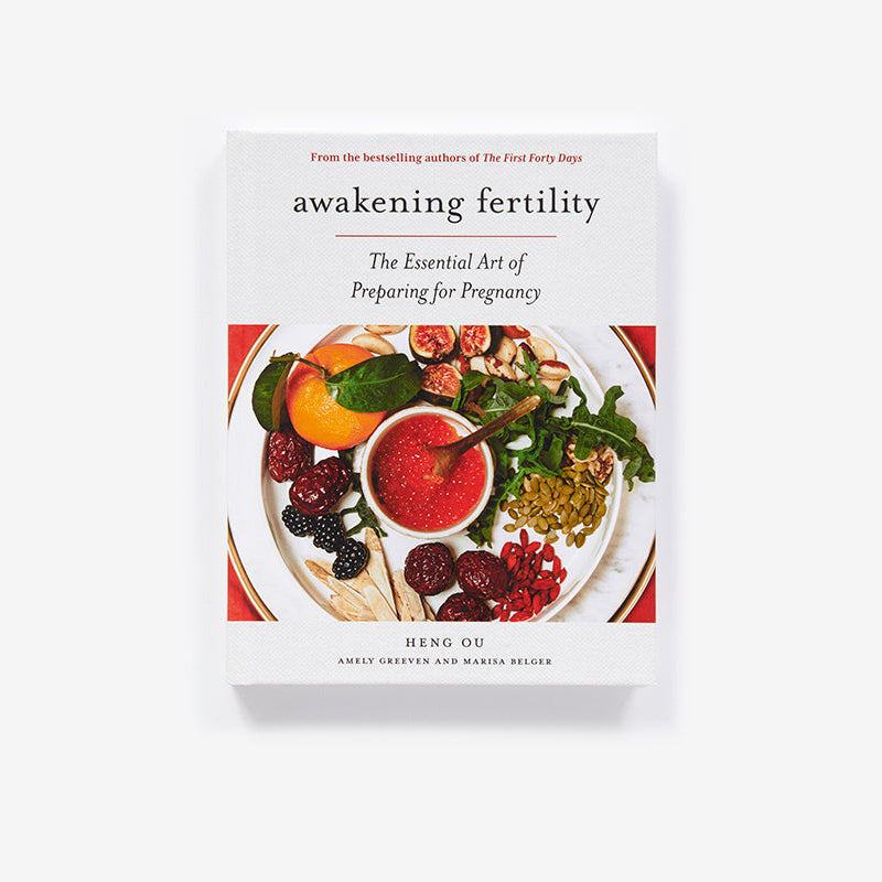 Book cover of 'Awakening Fertility' with a plate of fruits and vegetables on a white background