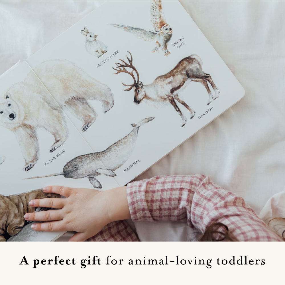 Children's book with illustrations of animals and a child's hand on a soft surface.