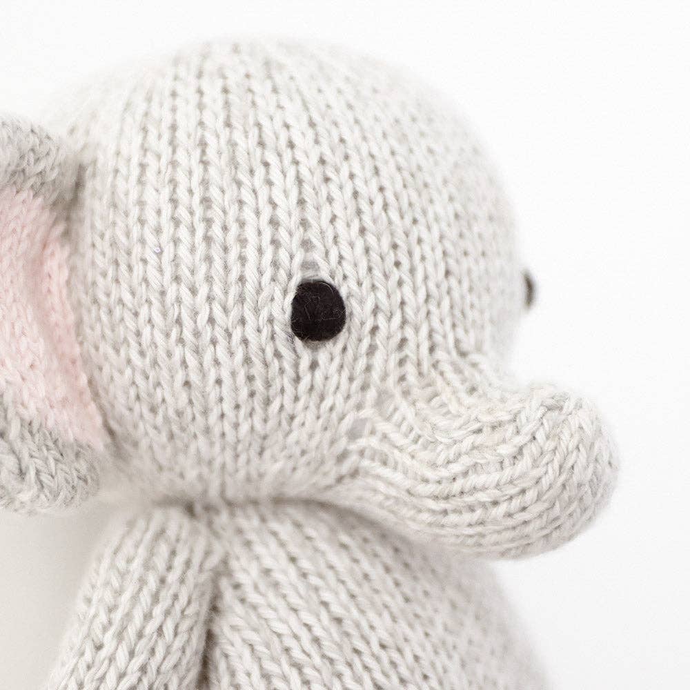 Close-up of a knitted elephant toy on a white background