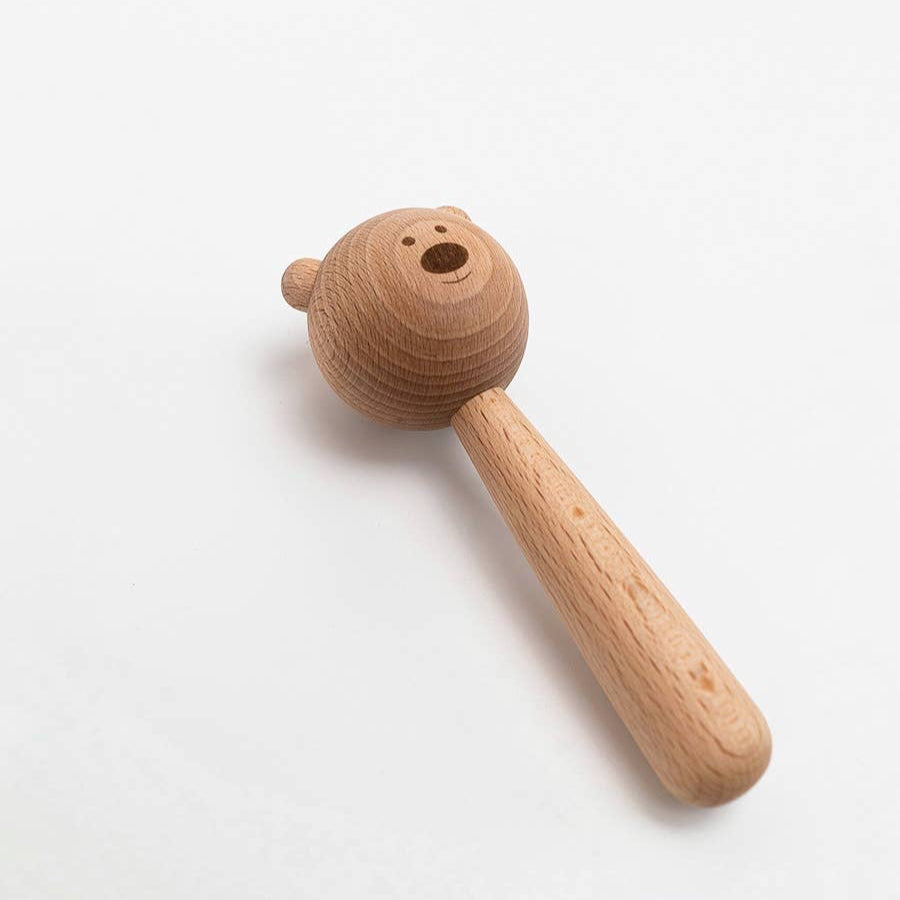 Wooden toy rattle with bear head on a white background