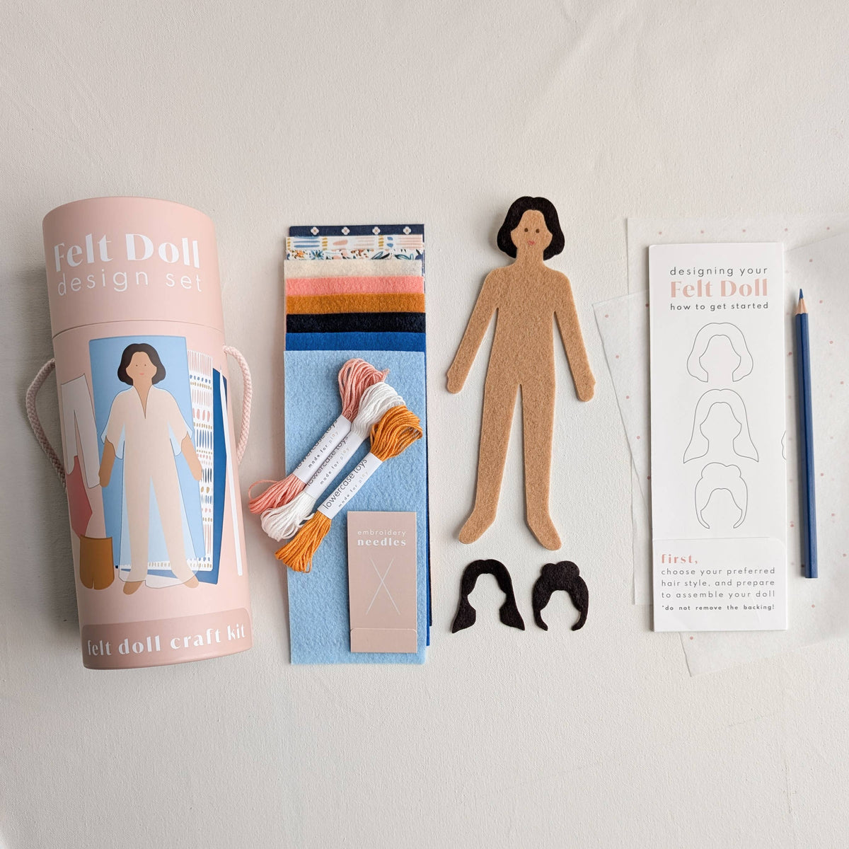 Felt doll craft kit with packaging, materials, and instructions on a white background