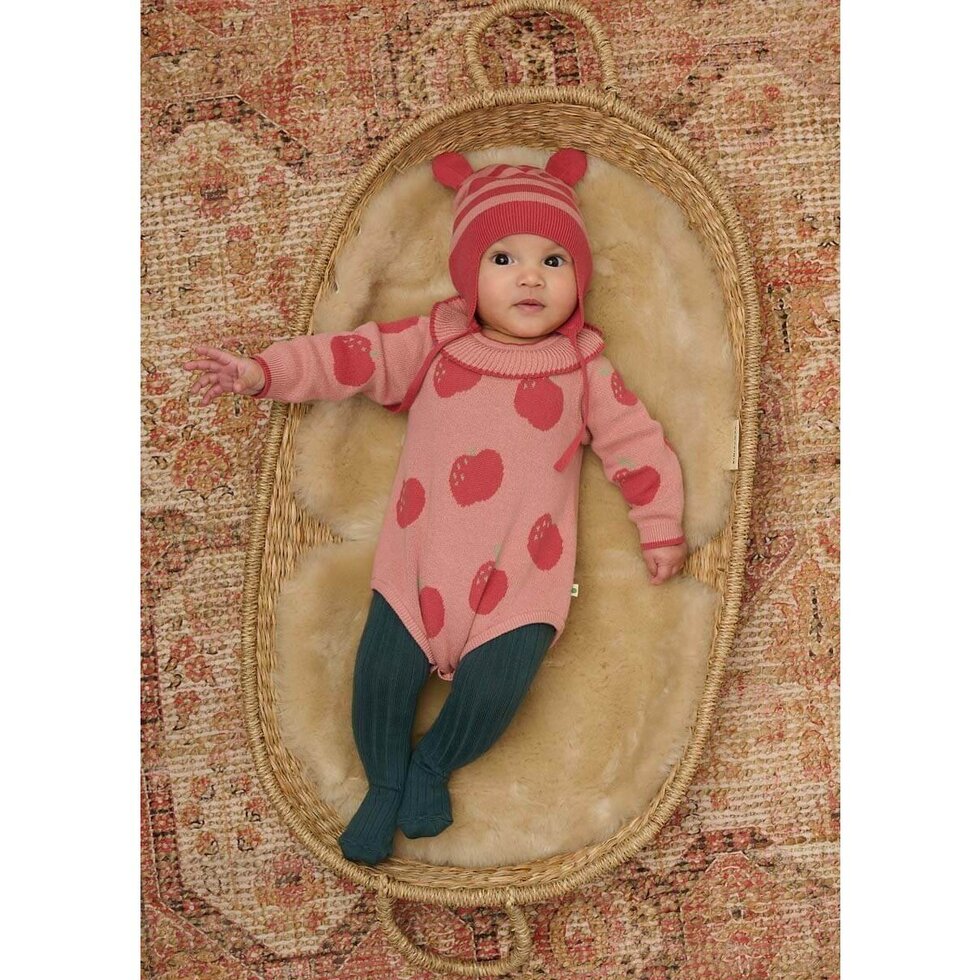 Pink knitted baby romper with apple pattern on a white background