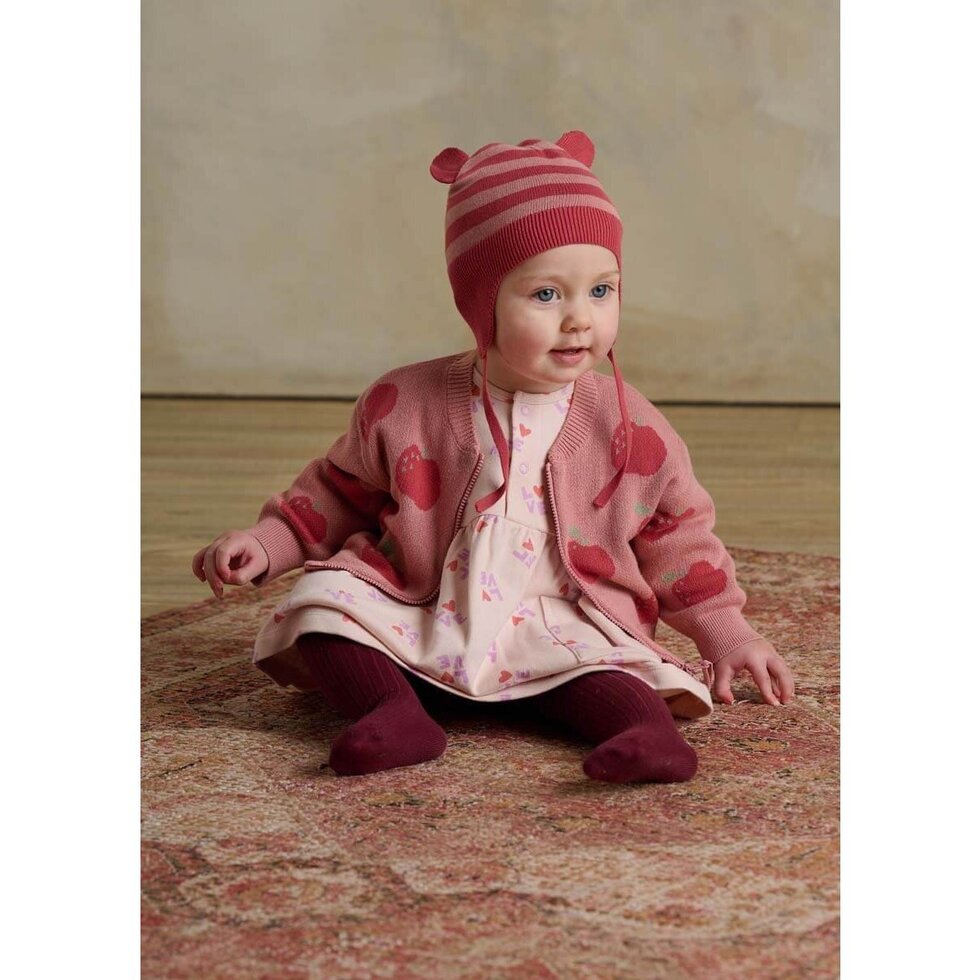 Pink children's cardigan with red apple pattern on a white background