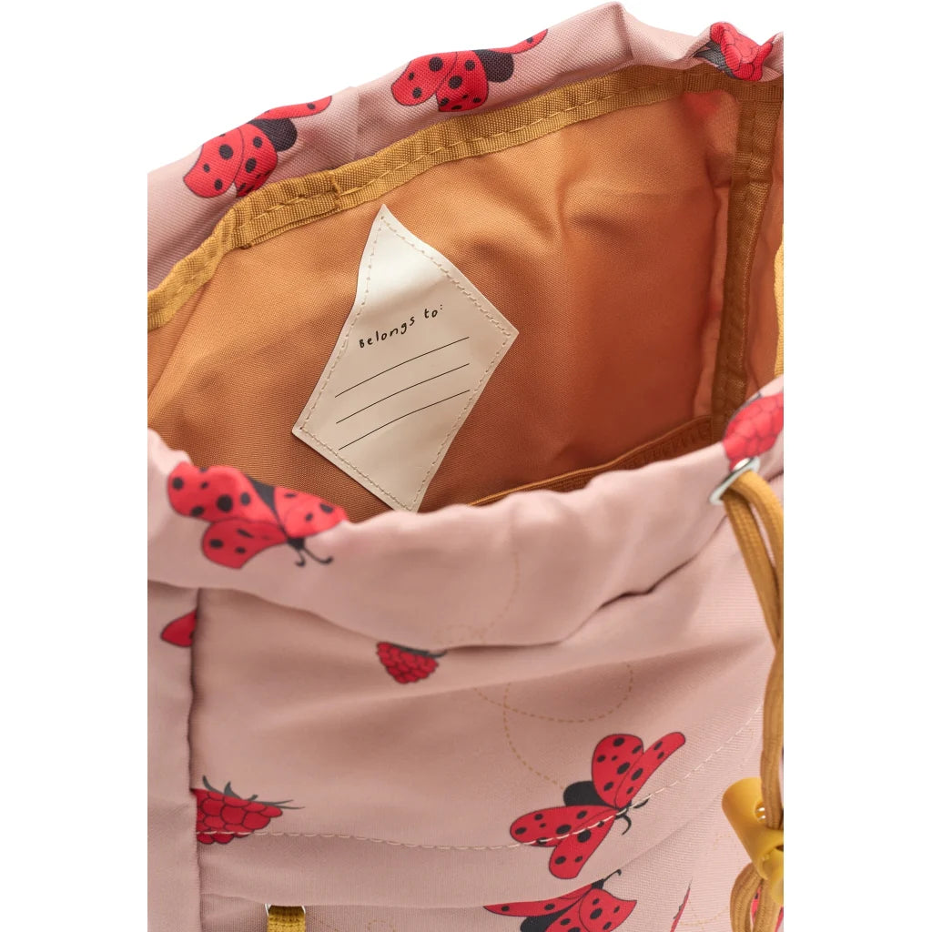 Children's backpack with ladybug pattern and name tag on a white background