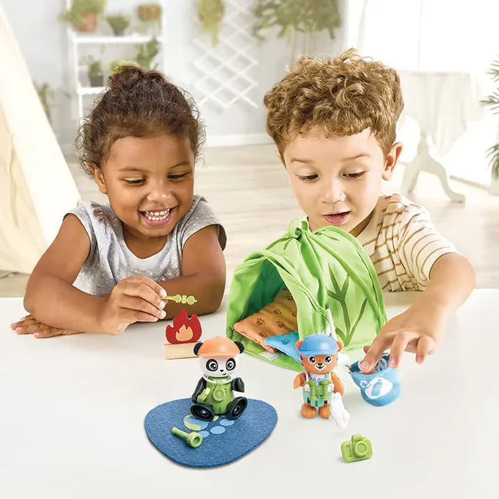 Two children playing with toy figures on a table.