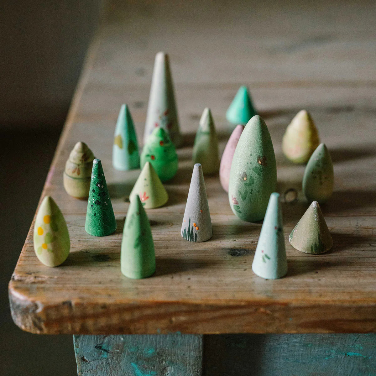 Set of wooden forest tree toys with a branded box on a white background