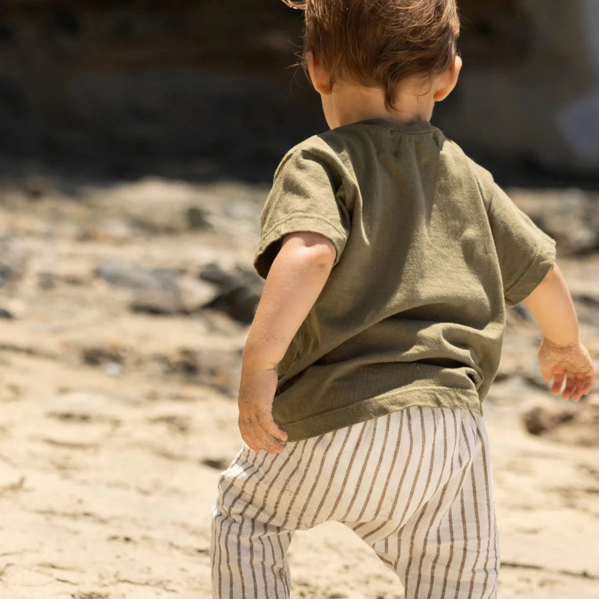 Child standing on a rock by the ocean