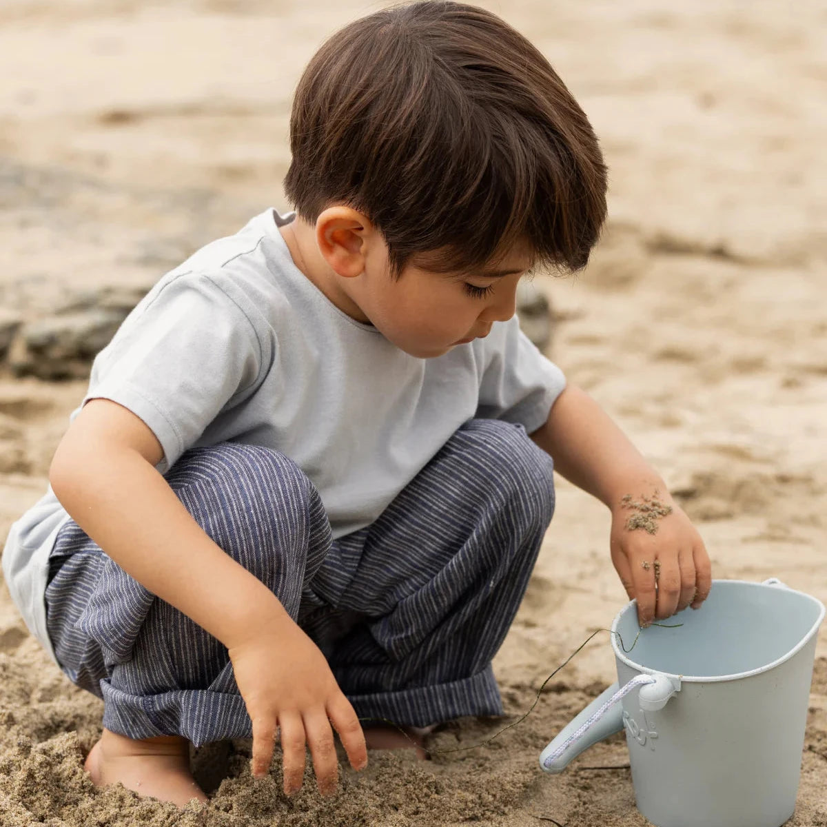 Child playing with sand on a beach