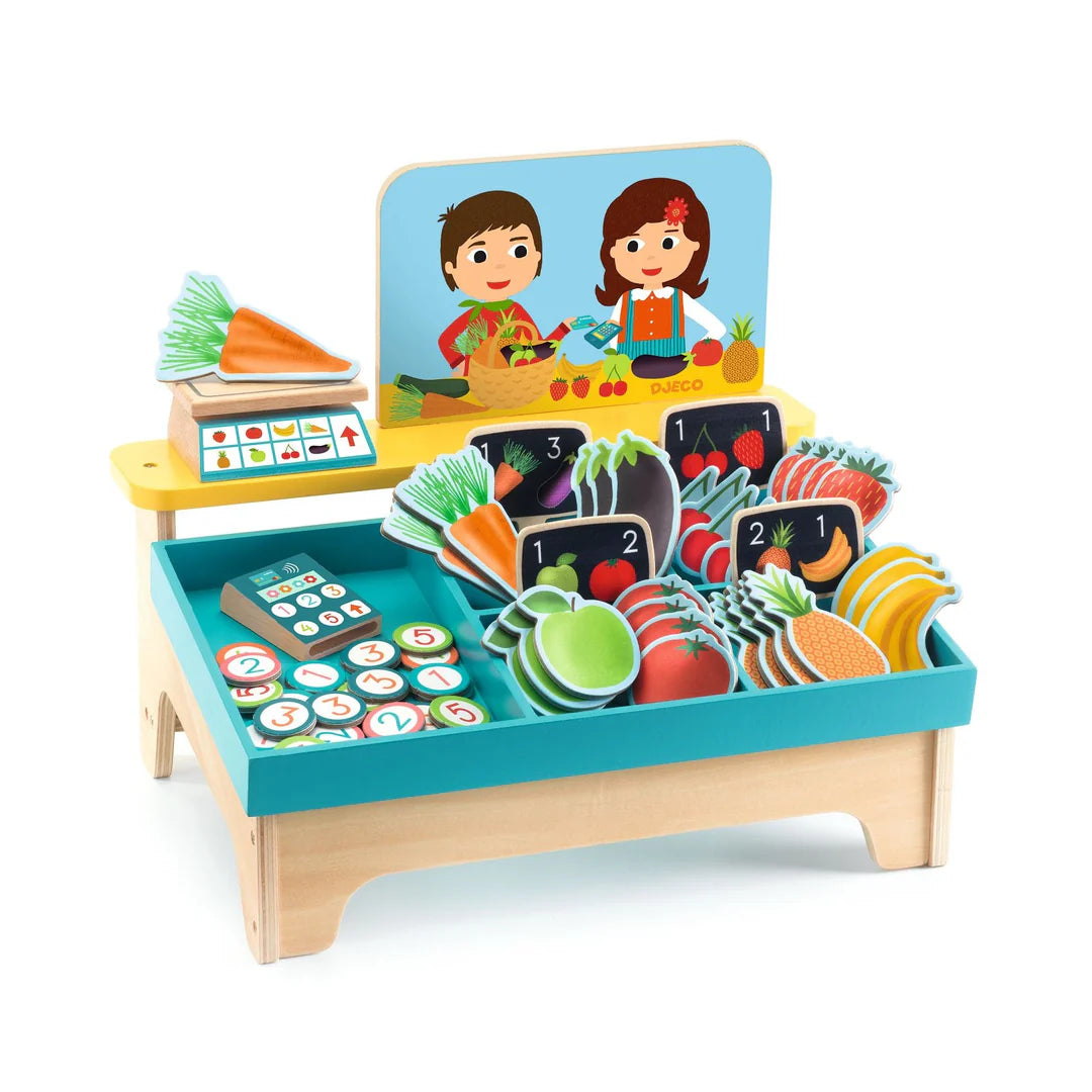 Toy grocery store set with fruits, vegetables, and cash register on a white background