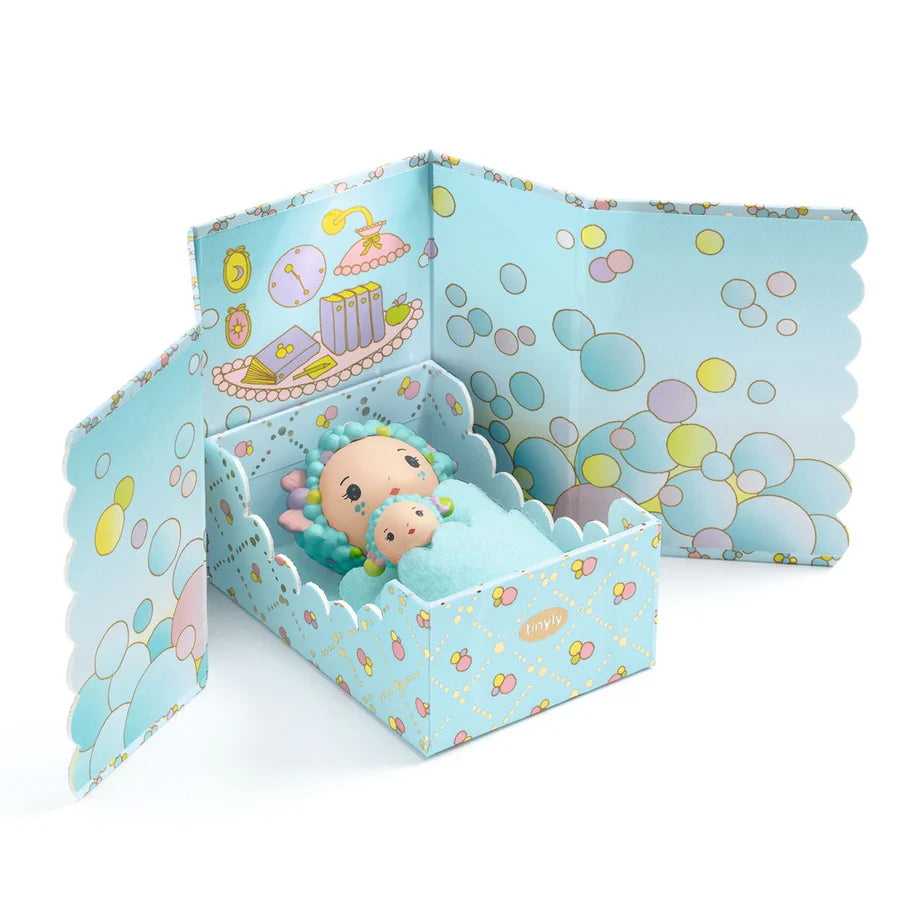 Toy figure in a decorative box with bubble-themed design on a white background