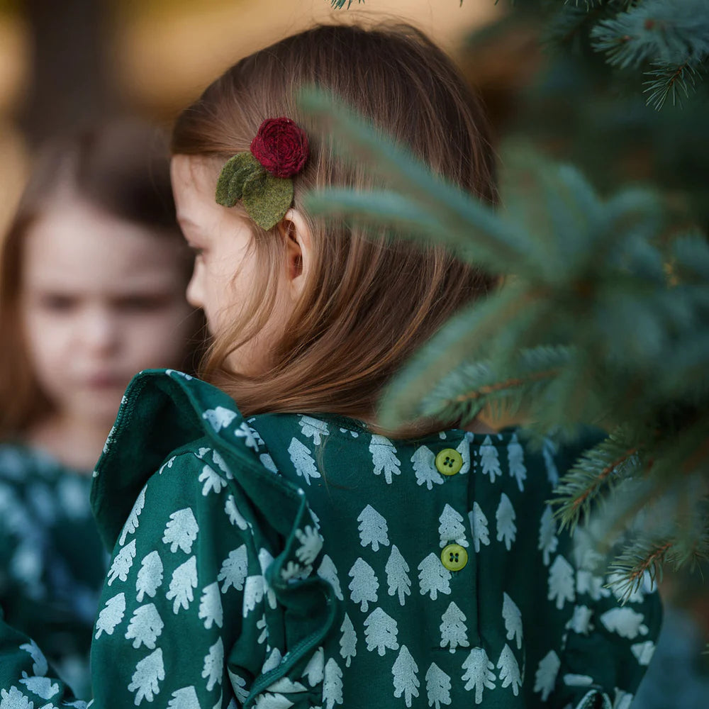 Child sitting at piano in tree printed dress