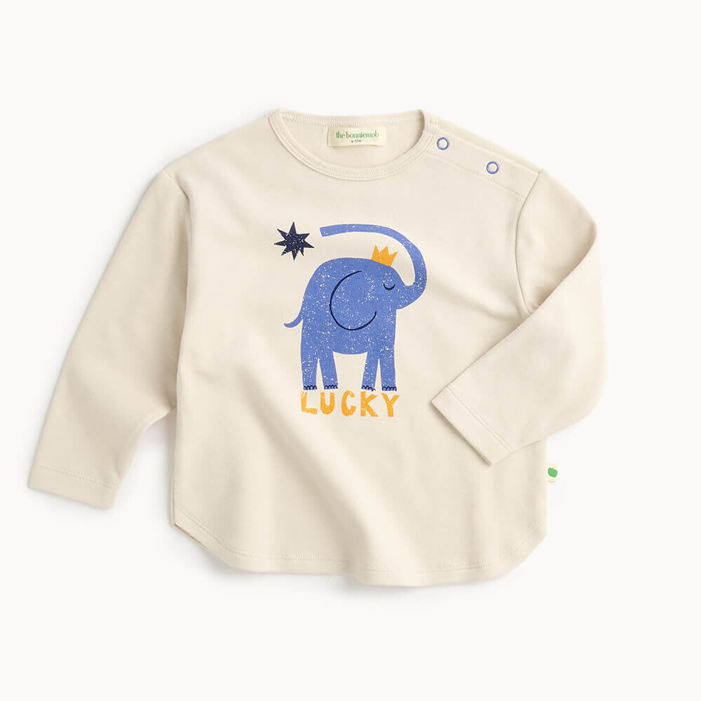 Beige long-sleeve shirt with a blue elephant graphic and 'Lucky' text on a white background