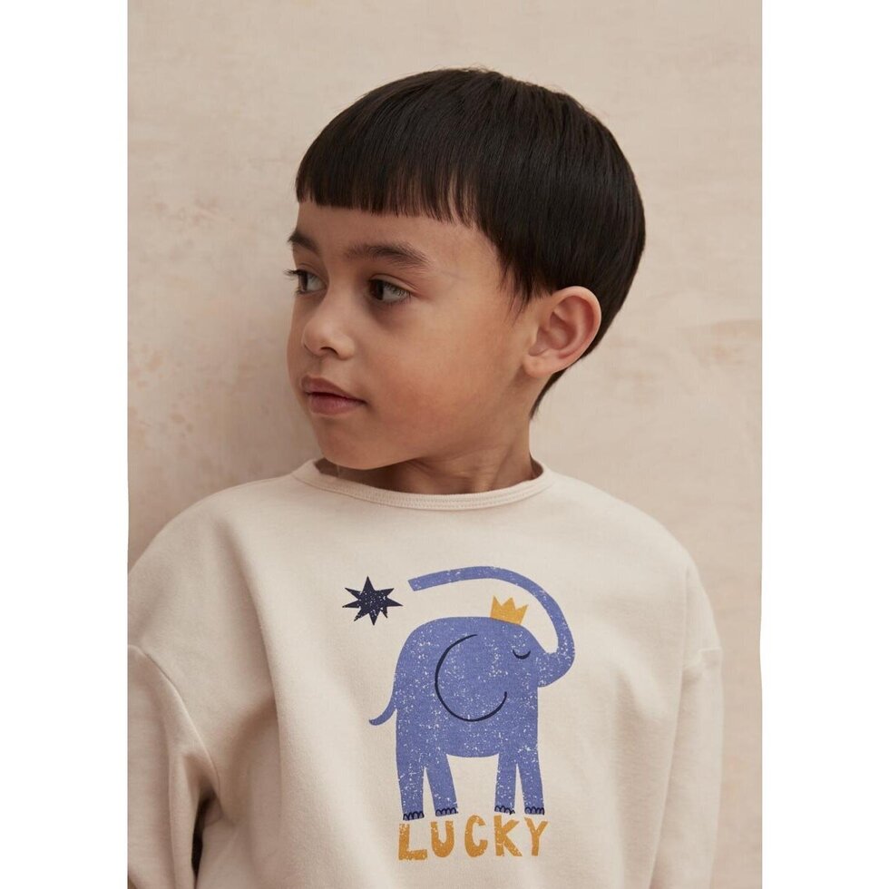 Beige long-sleeve shirt with a blue elephant graphic and 'Lucky' text on a white background