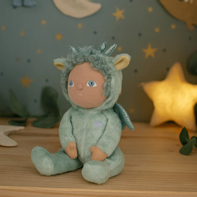 Soft toy dragon in a green outfit with star decorations on the wall.