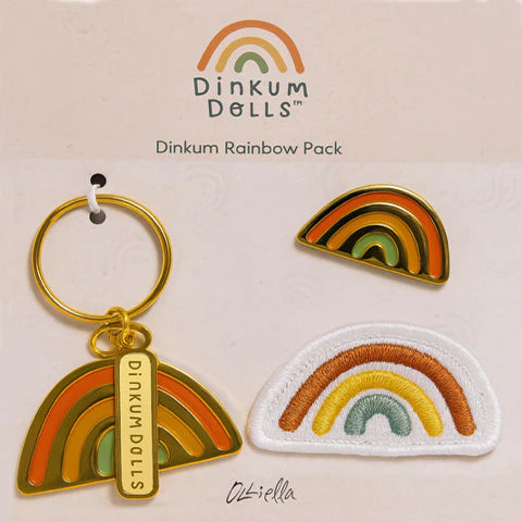 Dinkum Dolls rainbow-themed keychain, patch, and charm on a beige background