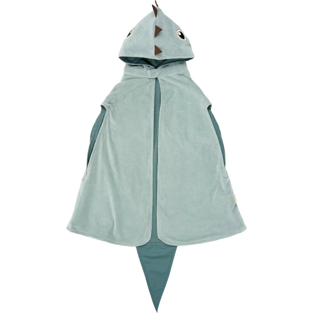 A children's hooded cape in a dusty sage green color, featuring a dino design with a pointed tail, mouth details on the hood, and dark teal side panels.