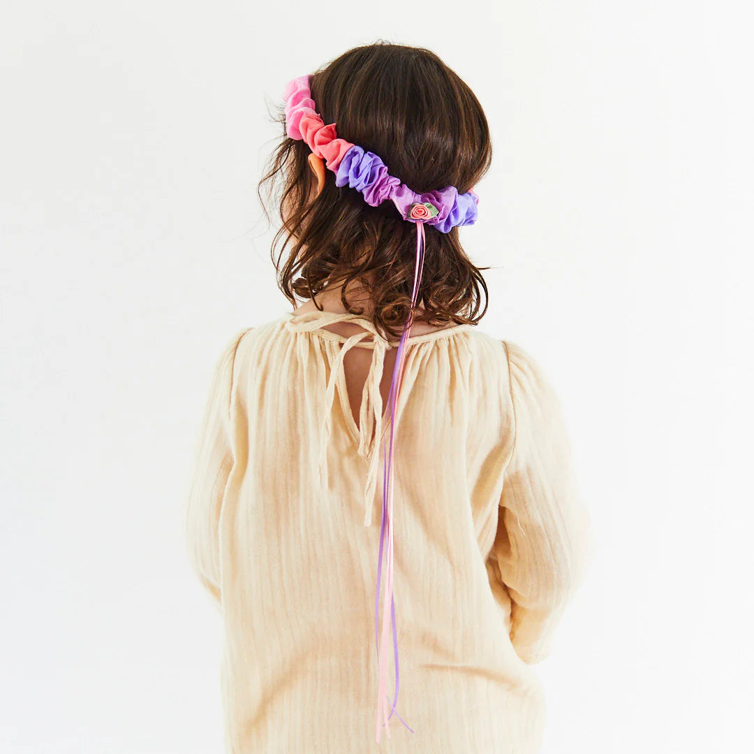 Silk garland made of pink and purple ruffled fabric on a light background