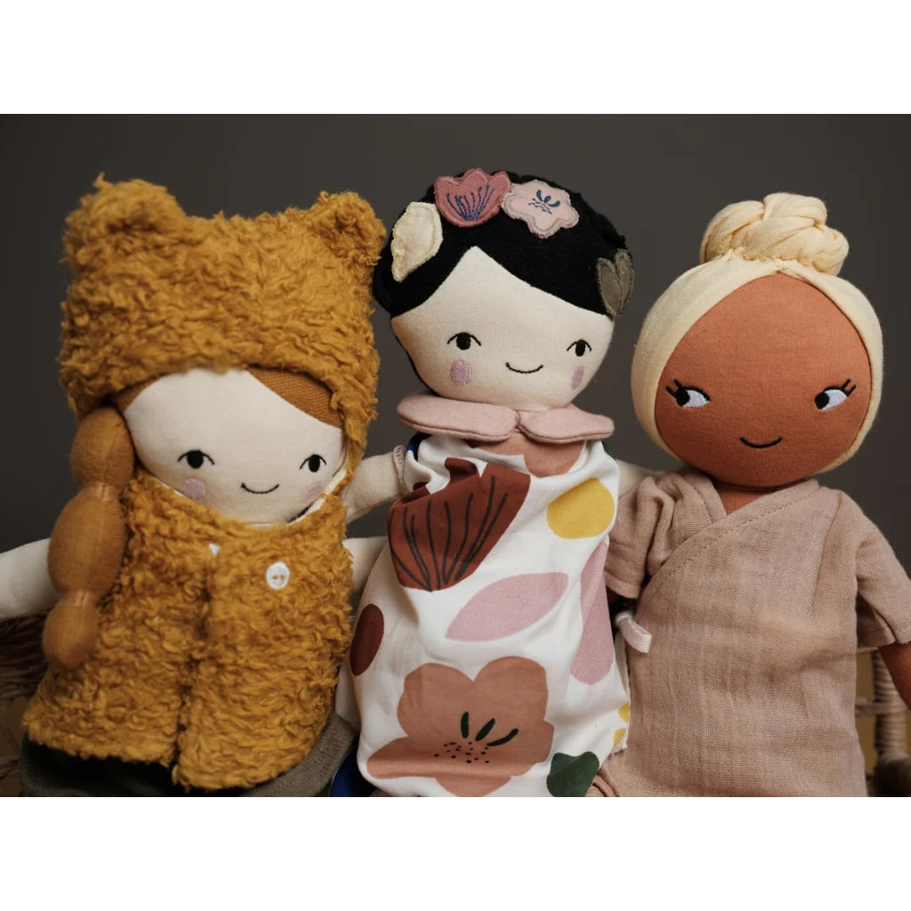 Three dolls with different outfits and hairstyles against a dark background