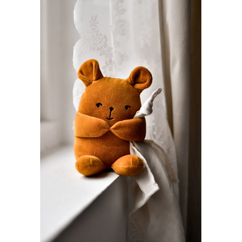 Brown plush toy resembling a bear holding a white blanket on a white background