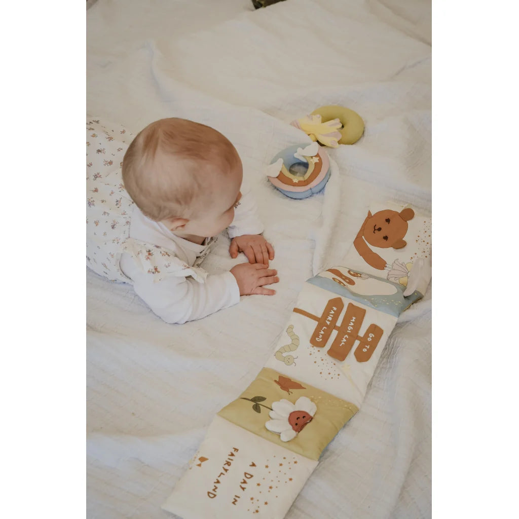 Children's soft book with bear illustration and text on a white background
