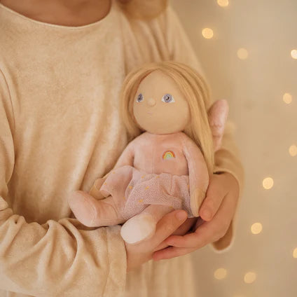 Child holding a soft toy with a blurred background of lights
