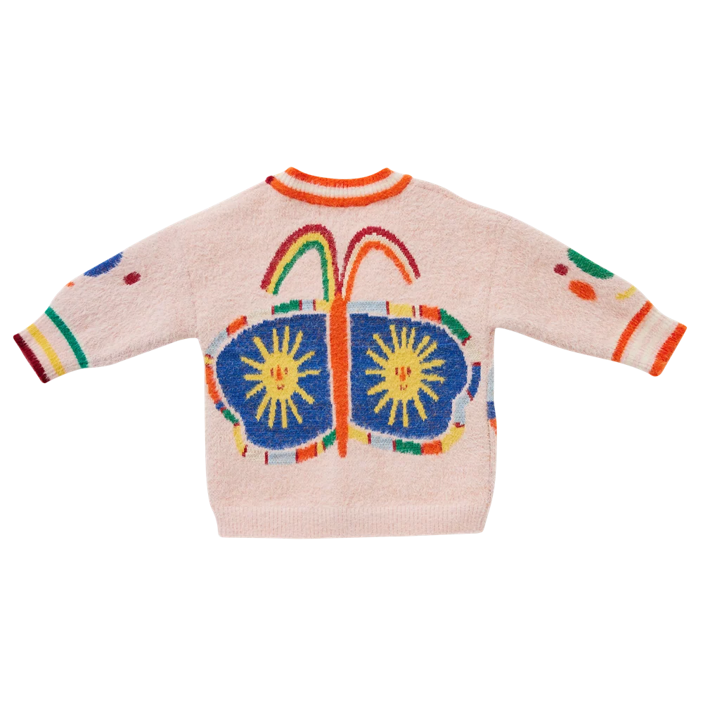 A light pink fuzzy knit sweater with a colorful butterfly design on the back, featuring blue wings with yellow sun motifs and rainbow accents.