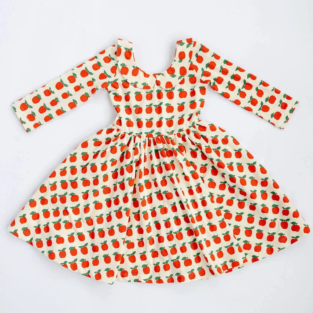 A long-sleeve dress with a white base and an all-over red strawberry print, laid flat on a white background.