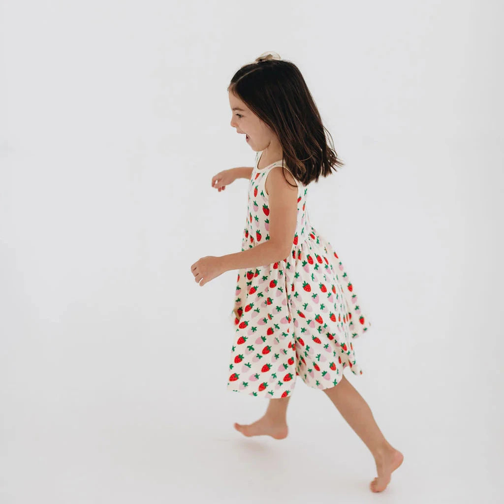 Young girl in a floral dress walking on a white background