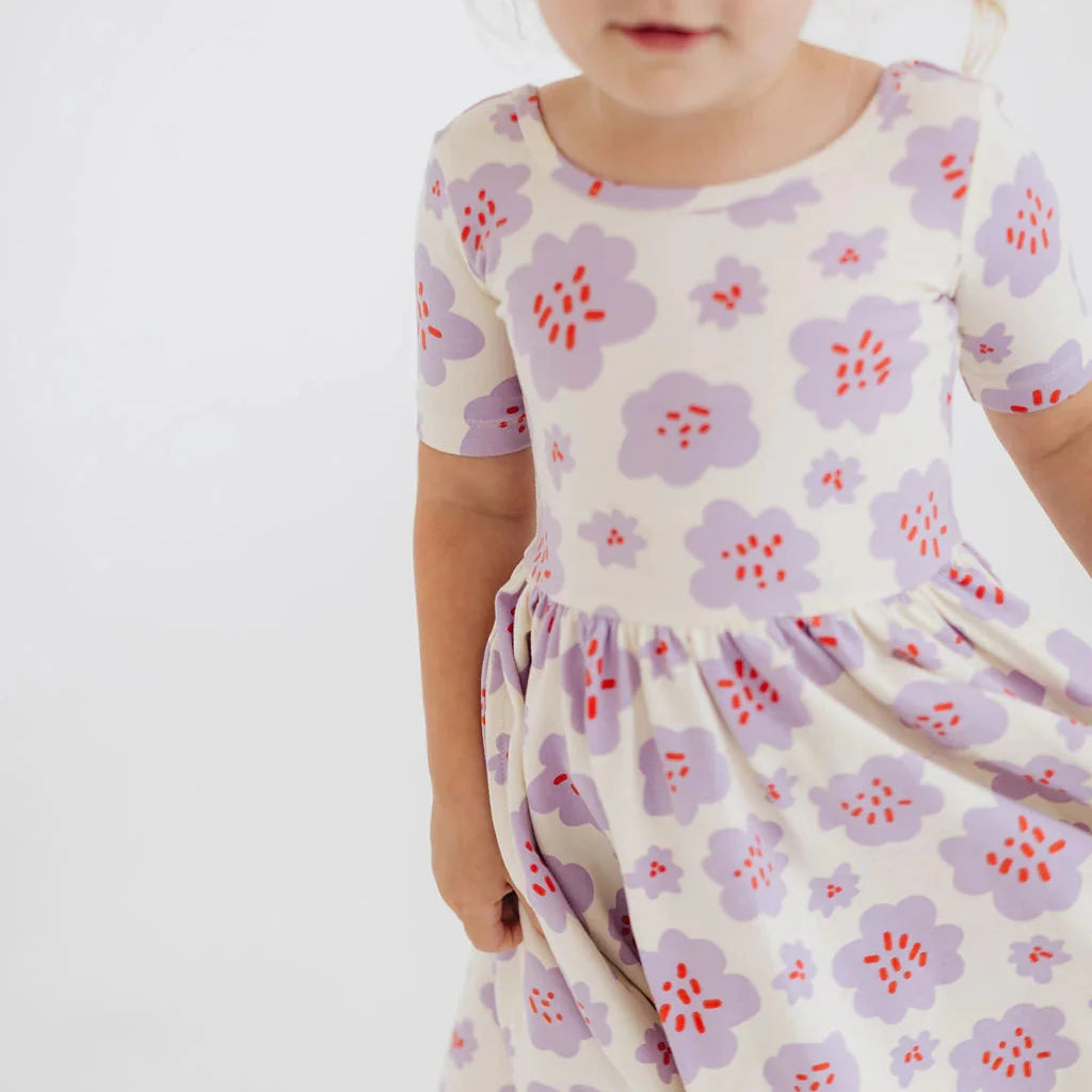 Child wearing a floral dress with a white background
