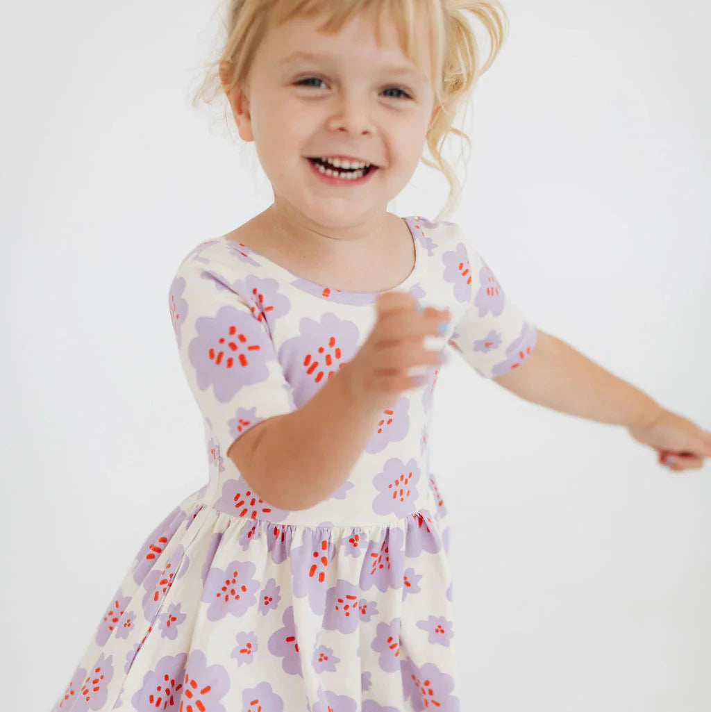 Child wearing a floral dress on a white background