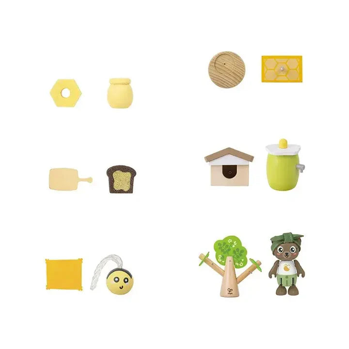 Set of wooden toys including a beehive, flowers, a house, and a bear on a white background