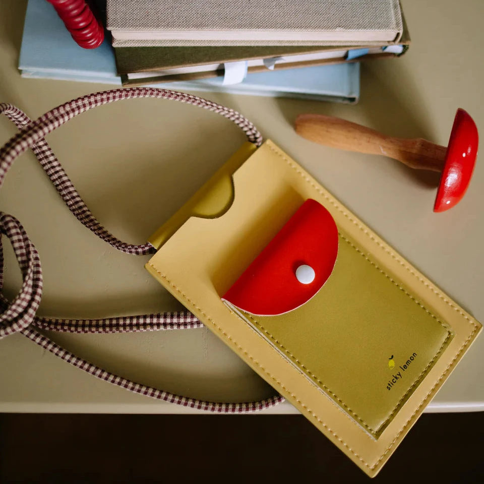  yellow leather phone pouch on a beige surface