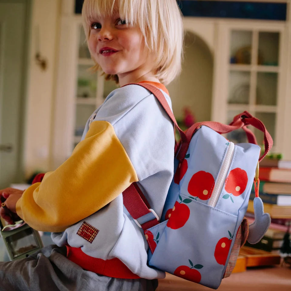 Child with a colorful backpack in an indoor setting