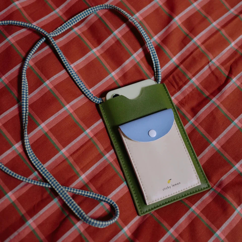 Green phone purse with blue accent on a red checkered fabric background