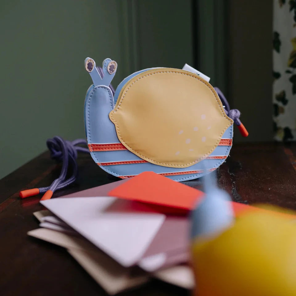 Colorful children's bag with a snail design on a wooden surface