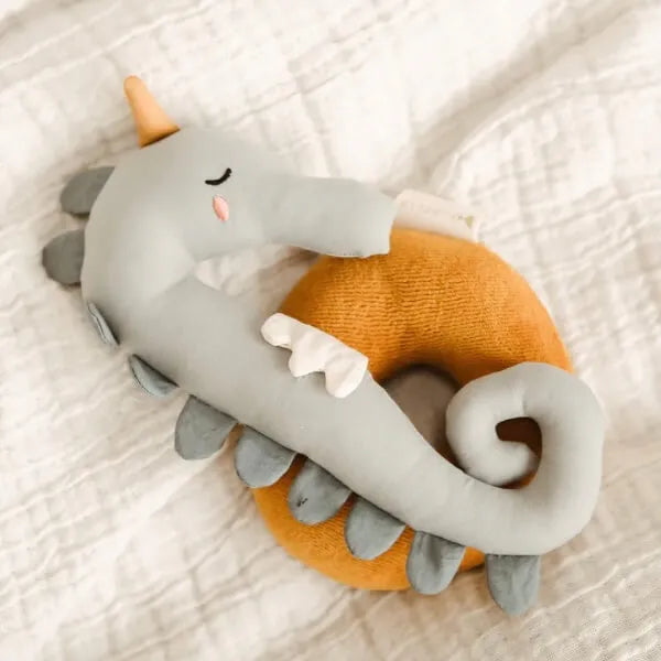 Plush seahorse toy with orange and gray  on a soft white background