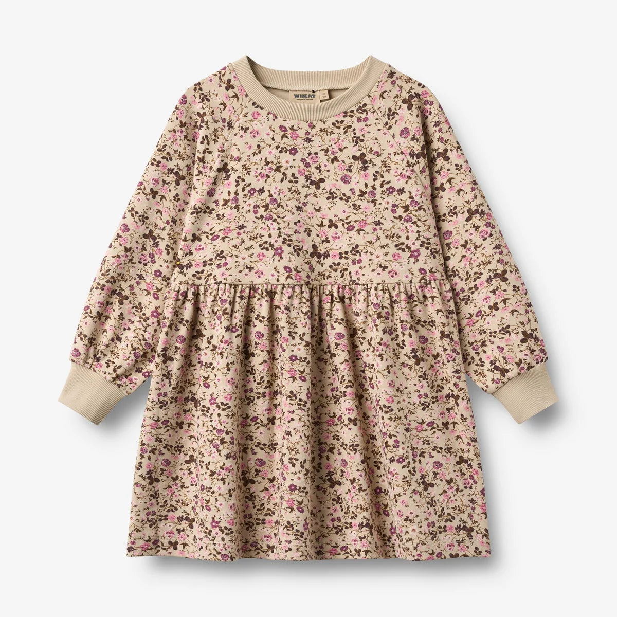 A long-sleeve children's dress with a dense pink and brown floral print on a beige background, featuring solid beige ribbed cuffs and a crew neck, shown flat on a light gray background.