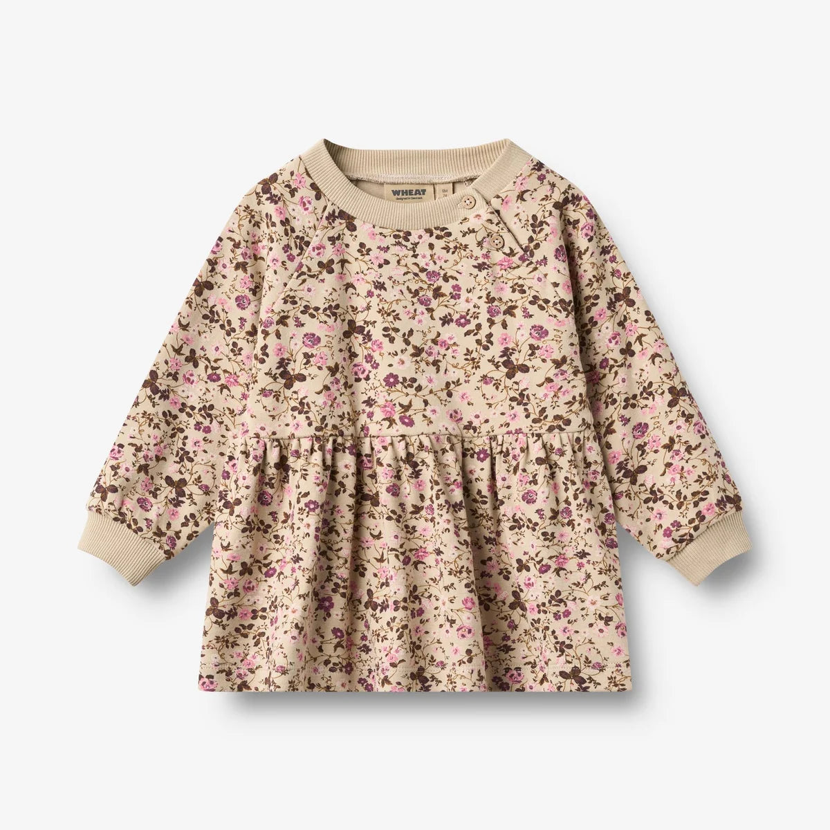 A long-sleeve baby dress with a beige base and a dense pink and brown floral print, featuring a gathered waist and ribbed cuffs.