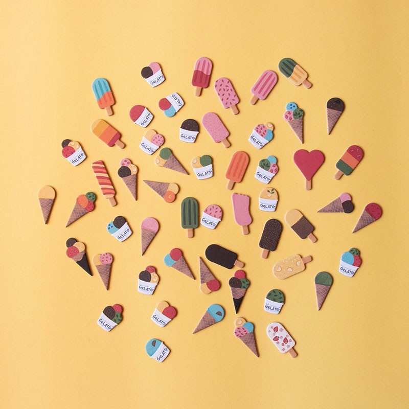 Colorful ice cream and popsicle-shaped pieces arranged in a pattern on a yellow background.
