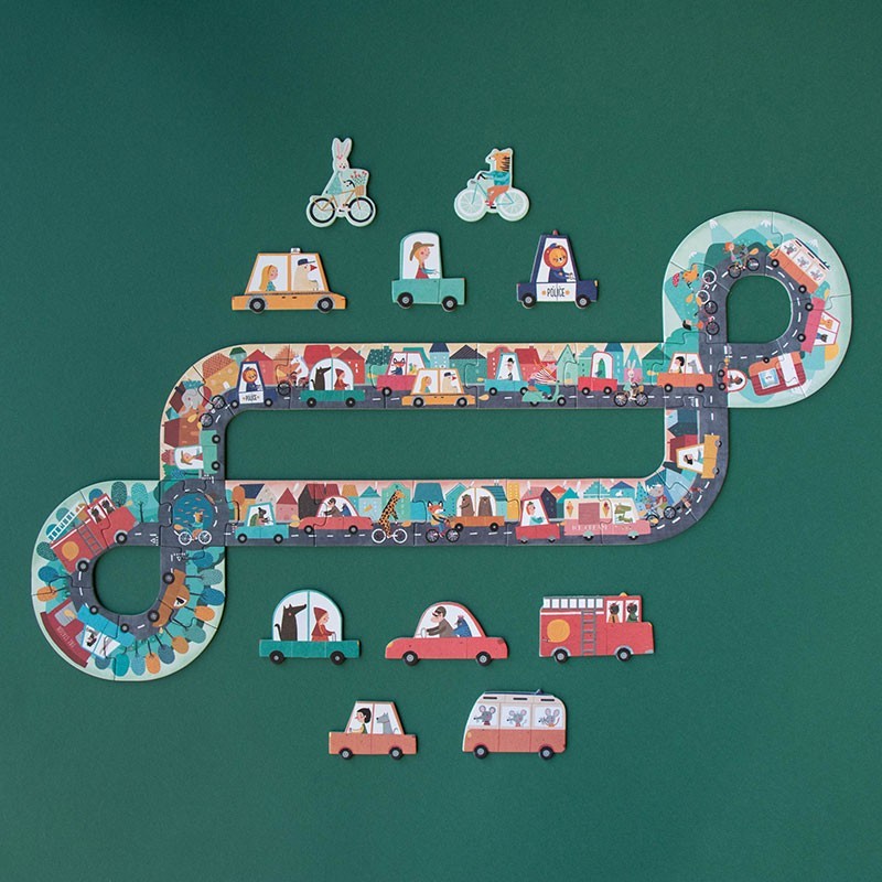 Colorful toy road set with various vehicle figures on a green background