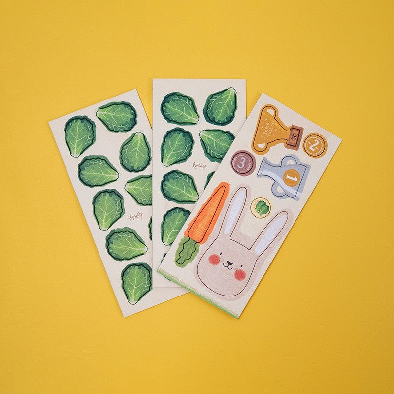 Three sheets of tokens  with green leaf patterns, a carrot, and a rabbit on a yellow background.
