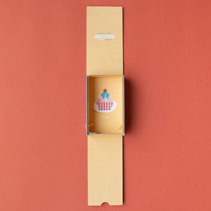 Unicorn-themed product in a cardboard box on a red background