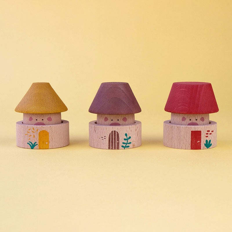 Three small toy houses with colorful roofs on a yellow background