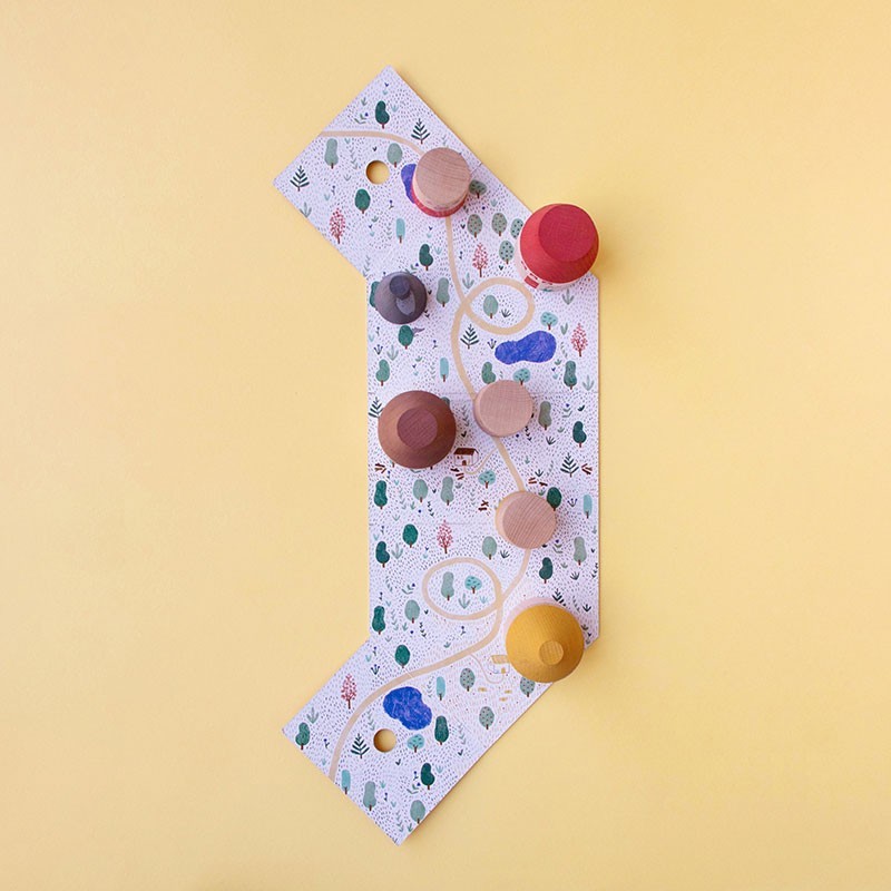 Colorful wooden toys on a patterned board against a yellow background