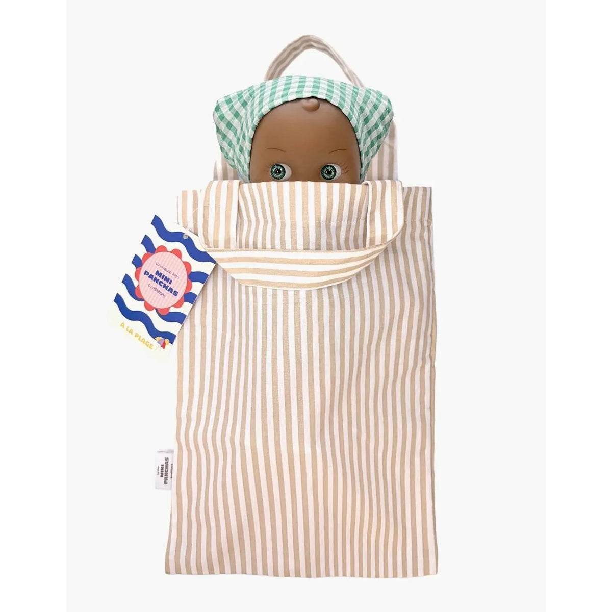 A doll in a cloth bag with a beige and white vertical stripe pattern, featuring a green and white checkered bonnet on the hood. A small tag is attached to the side, and the doll's head is visible peeking out from the top.