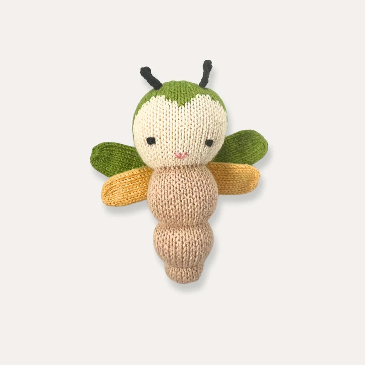 A knitted bee plush toy with a cream-colored body, green head and wings, and yellow wings, centered on a light gray background.