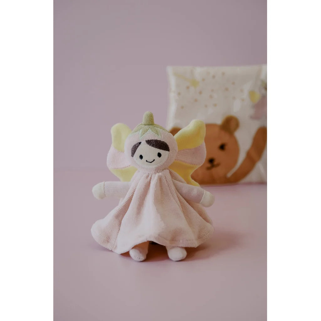 Toy fairy with a pink dress on a pink background