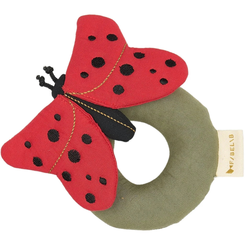 Red ladybug-shaped rattle with black spots on a white background