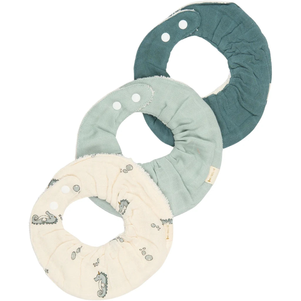 Three fabric bibs  in teal, mint, and beige on a white background
